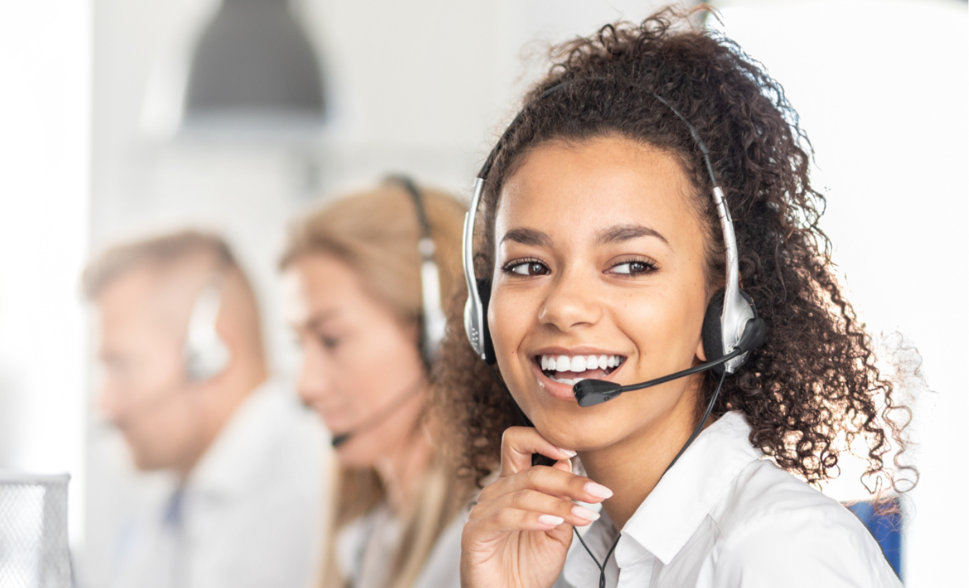 Customer service representative on headset speaking to customer and smiling